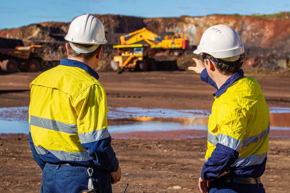 Two mining professionals discussing an open-pit operation